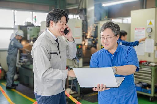 工場の現場でタブレットを使う作業員